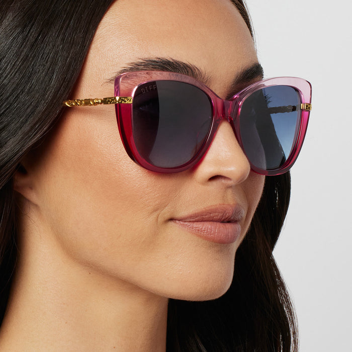 on model - female wearing harry potter x diff eyewear hermione granger 2.0 sunglasses with a ombre pink frame, gold temples and blue bell gradient lenses angled view