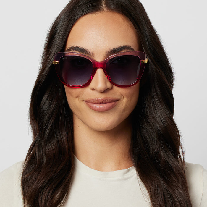 on model - female wearing harry potter x diff eyewear hermione granger 2.0 sunglasses with a ombre pink frame, gold temples and blue bell gradient lenses front view