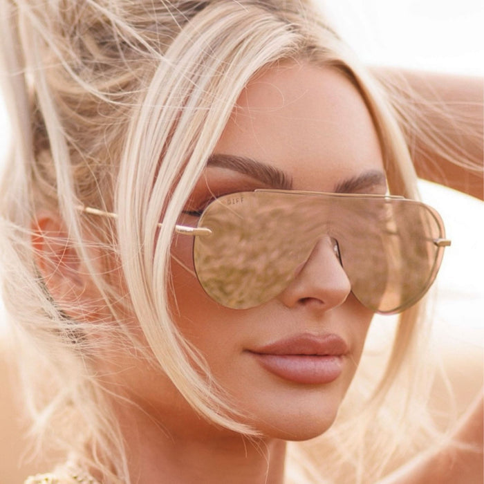lifestyle - blonde woman wearing the Imani shield style aviator womens sunglasses in the color pink Cherry Blossom from DIFF Eyewear