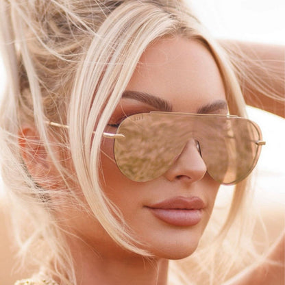 lifestyle - blonde woman wearing the Imani shield style aviator womens sunglasses in the color pink Cherry Blossom from DIFF Eyewear