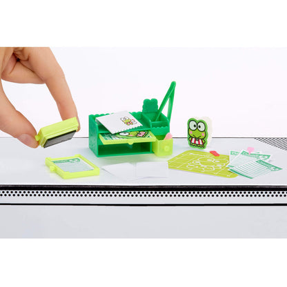 Green mini desk organizer with a hand using a stamp on a white surface