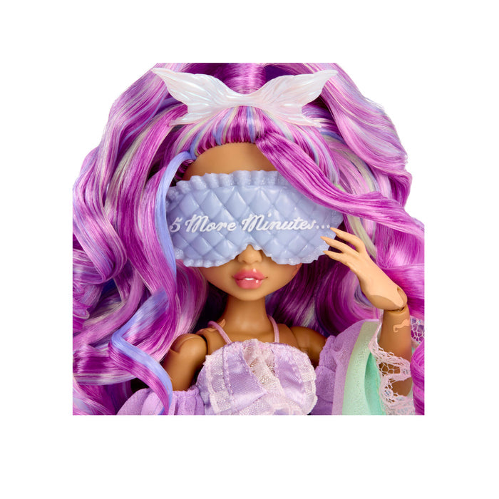A doll with long wavy purple and pink hair wearing a white bow, a lavender quilted eye mask with the text '5 More Minutes.