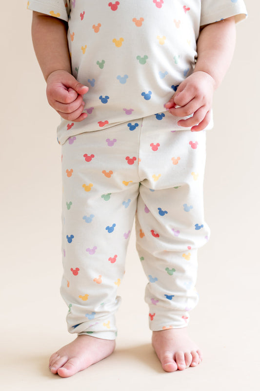 Child wearing pastel mickey head pattern pant  on a plain background