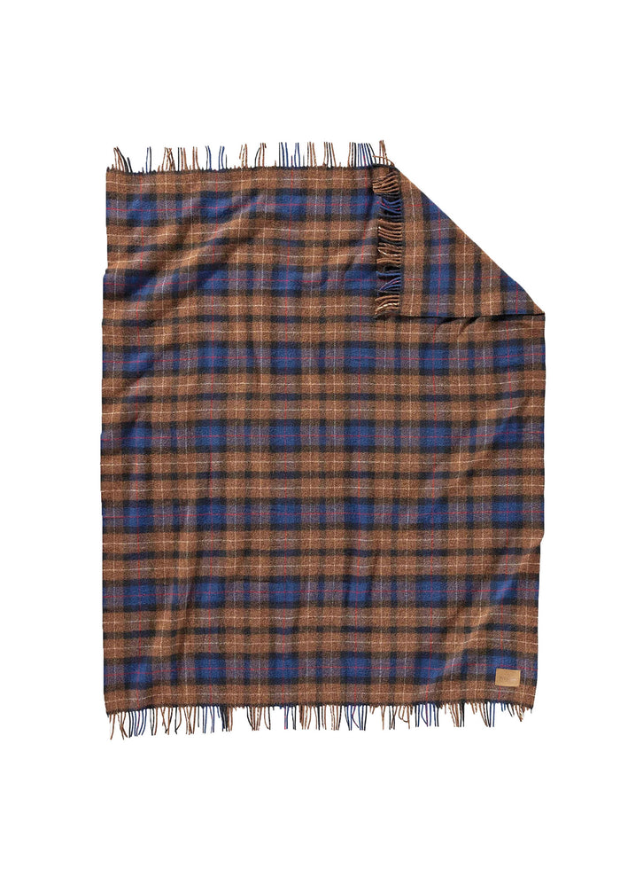 A brown and blue plaid wool blanket with fringed edges, neatly folded at one corner, lies flat against a white background.