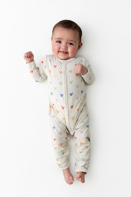 Baby wearing a snap romper in a mickey head pattern