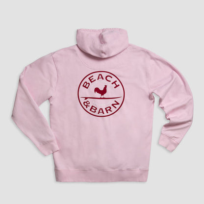A light pink hoodie with a dark red circular logo on the back that reads BEACH & BARN and features a silhouette of a chicken in the center.