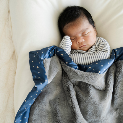 Baby boy snuggled with Satin back mini baby blanket in Twinkle Star print.