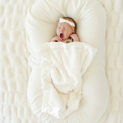 Baby girl snuggled with Ivory Satin border Mini baby blanket.