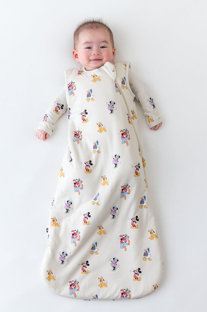 Baby in a sleep sack with mickey and friends pattern
