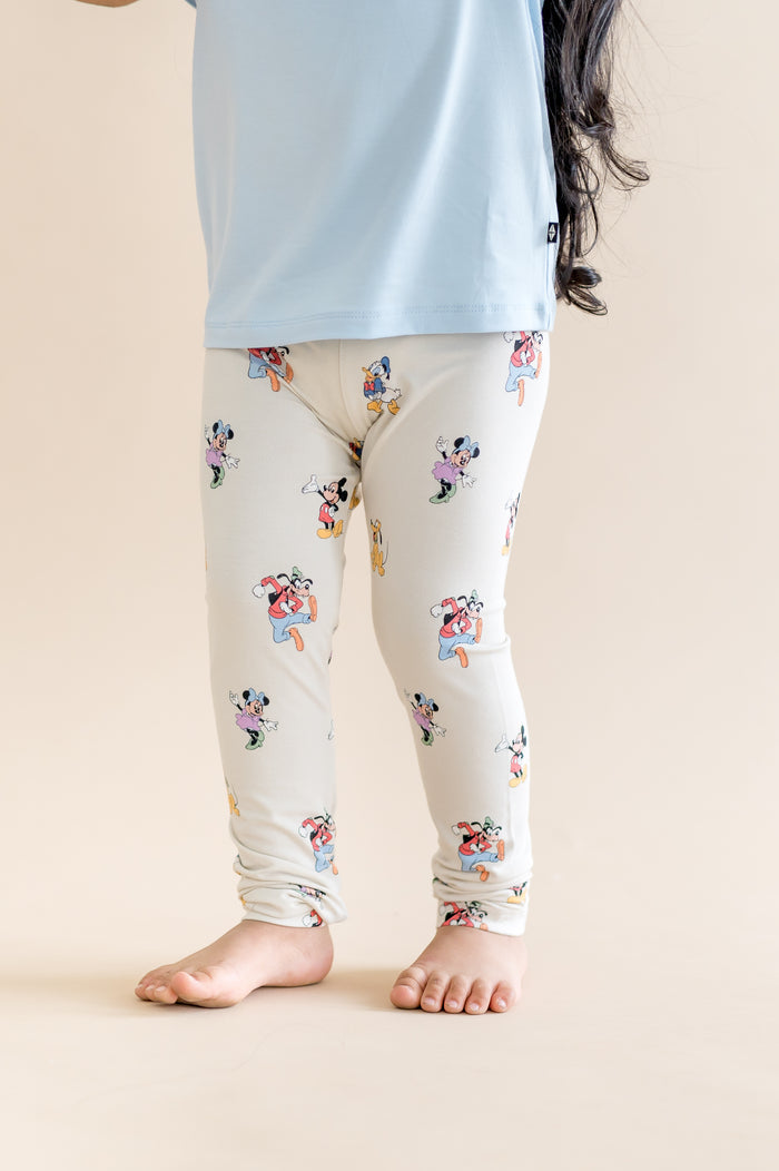 child wearing mickey and friends patterned leggings with a blue shirt