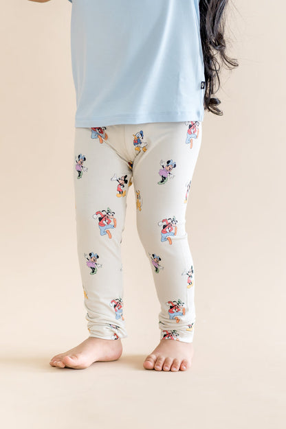 child wearing mickey and friends patterned leggings with a blue shirt