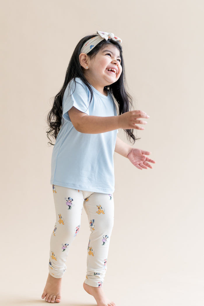 child wearing blue tshirt and mickey and friend printed leggings