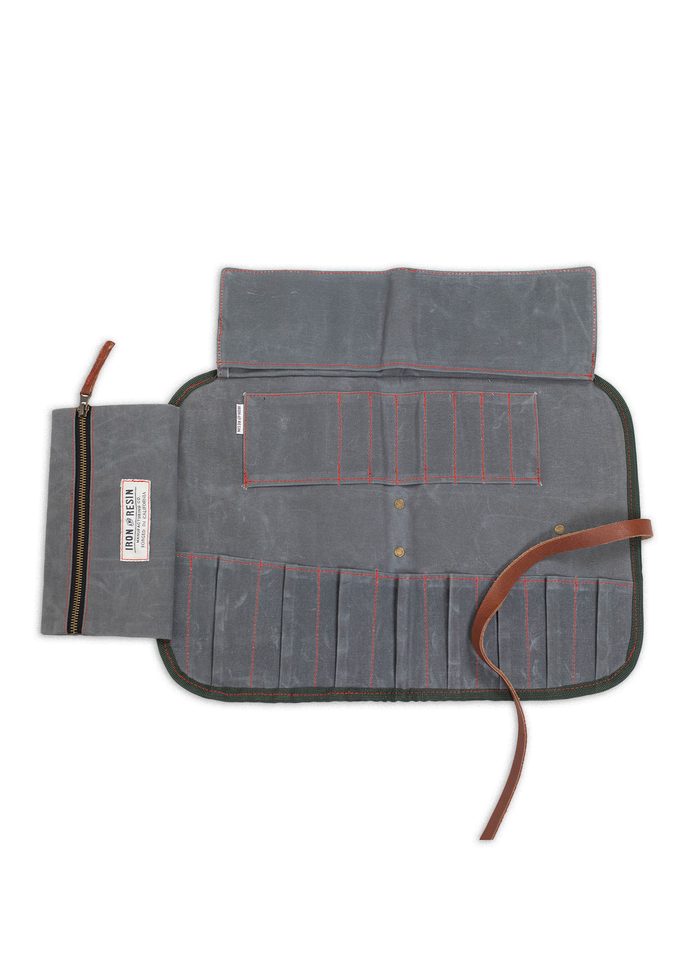 Open gray tool roll with multiple pockets and a leather strap, designed for organizing tools. Zippered pouch on the left.