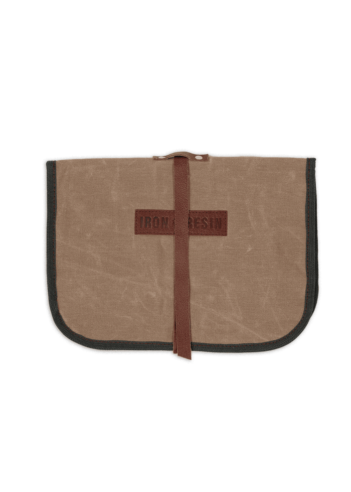 Brown canvas pouch with "Iron & Resin" logo, secured by a leather strap, featuring black trim on the edges.