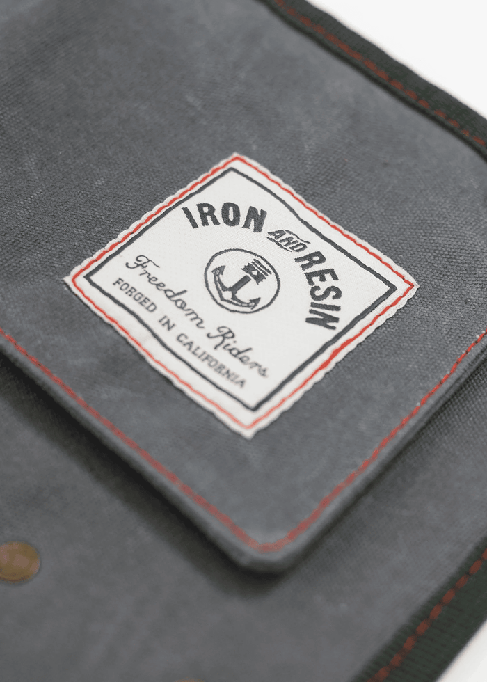 Close-up of a gray fabric with an "Iron and Resin" label, featuring an anchor logo and "Forged in California" text.
