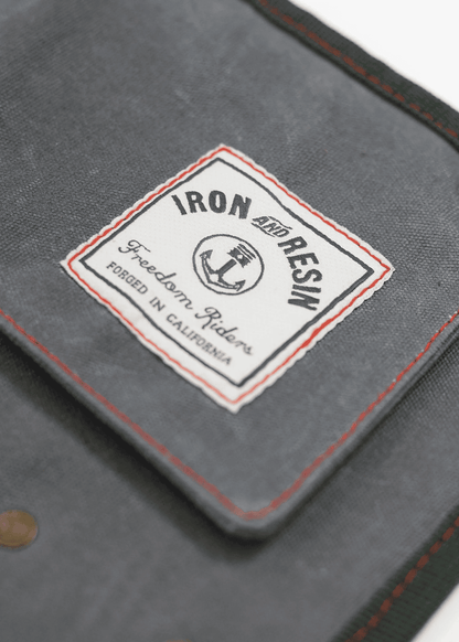 Close-up of a gray fabric with an "Iron and Resin" label, featuring an anchor logo and "Forged in California" text.