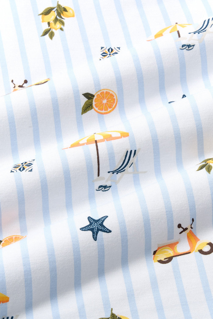 Close up of the Bamboo fabric: A repeating, all-over print featuring: a bunch of three lemons with stems, leaves, and a white blossom; an orange-and-yellow Vespa; an orange slice circle; a white sailboat with three white seagulls in the distance; a white Italian ceramic tile painted with a navy, orange, and pale yellow design; a sling beach chair with white and navy stripes next to an orange-and-white striped beach umbrella, over a background pattern of white and light blue stripes.