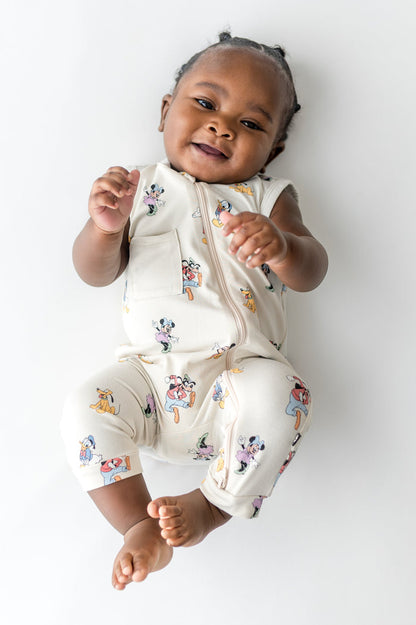 Baby in a sleeveless zippered romper with a mickey cartoon pattern